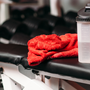 serviette et bouteille posées sur un banc de musculation dans une salle de sport