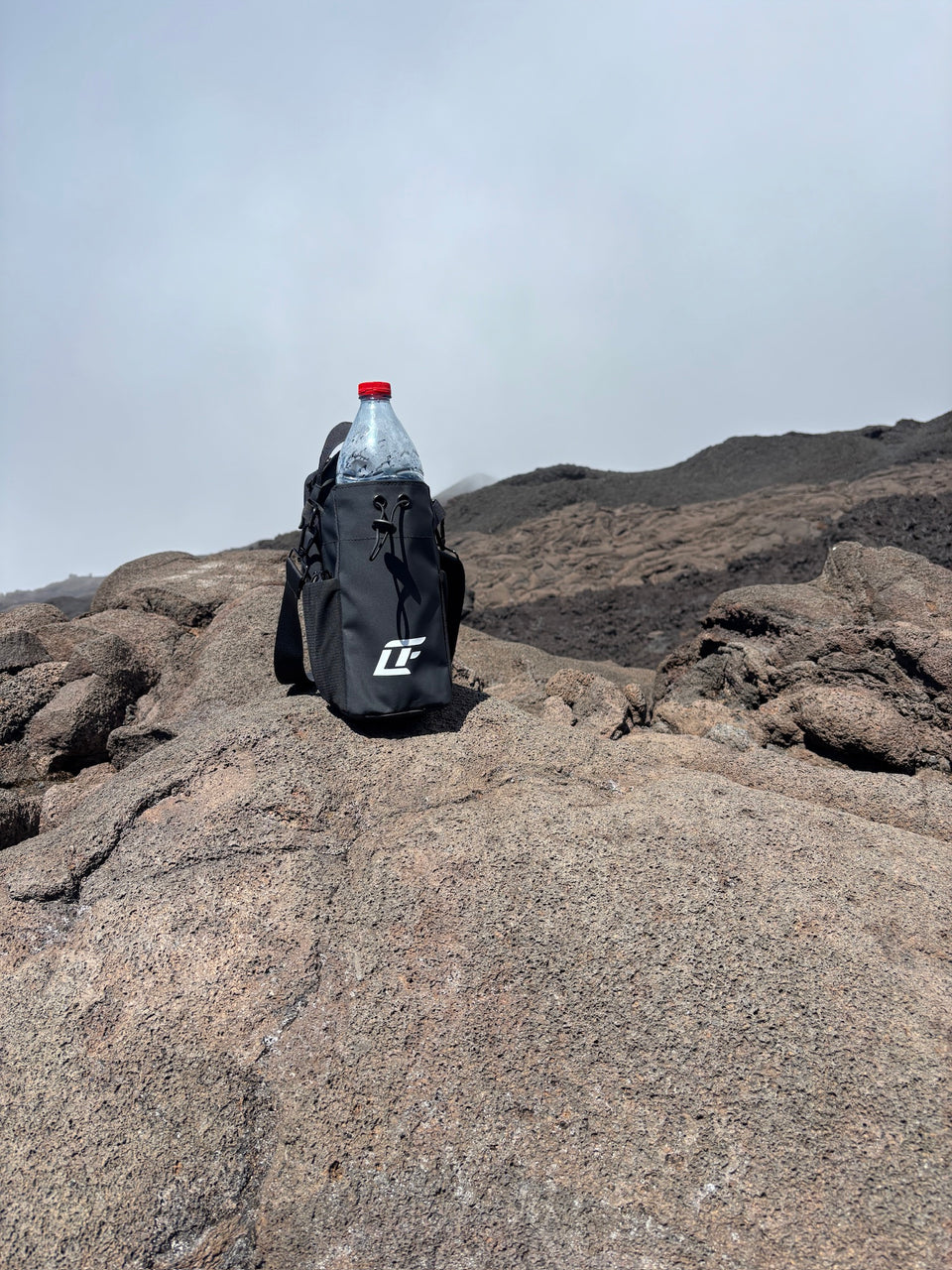 Sac de sport magnétique LIUMFIT posé sur roche volcanique en extérieur.