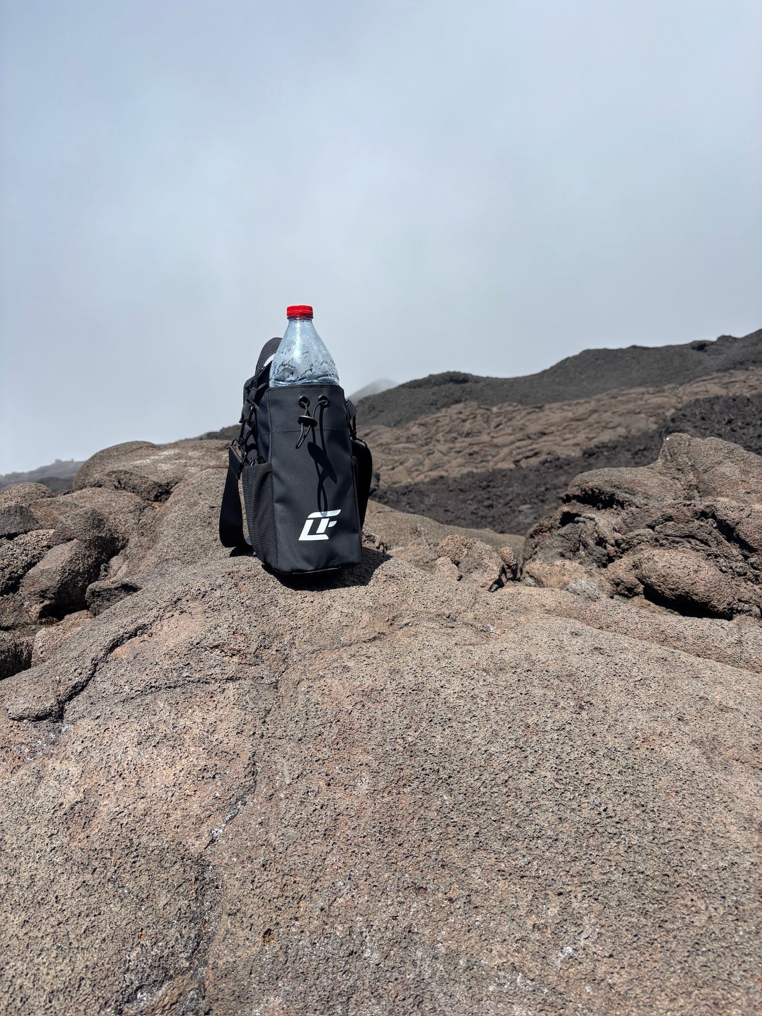 Sac de sport magnétique LIUMFIT posé sur roche volcanique en extérieur.